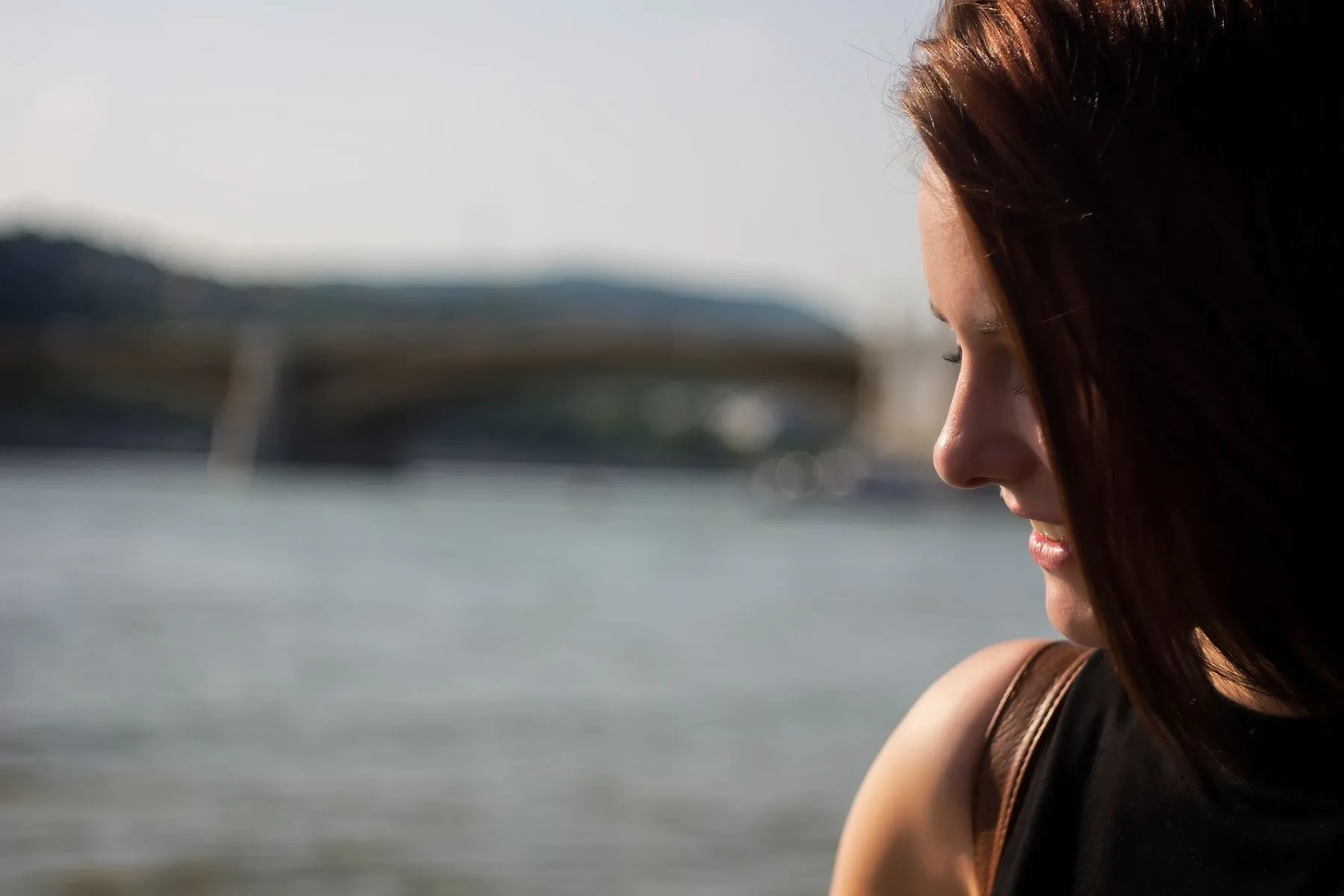 A woman in profile beside a river with the light behind her, two arrows marking the direction it comes from